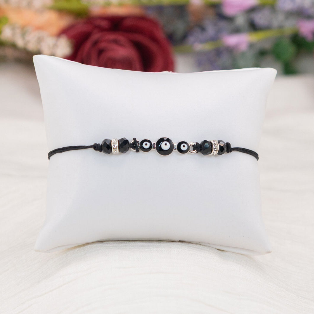 Black Evil Eye Bracelet Knotted on a Pillow - Down To Earth