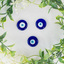 Load image into Gallery viewer, Evil eye Charm top down with plants around on a style background - Down To Earth
