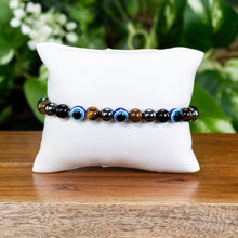 Load image into Gallery viewer, Evil Eye Crystal Bracelet on a pillow displayed on a styled background - Down To Earth
