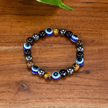 Load image into Gallery viewer, Evil Eye Crystal Bracelet up close top down displayed on a styled background - Down To Earth
