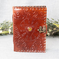 Evil Eye Leather Journal front facing with plants displayed on a styled background - Down To Earth