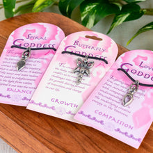 Load image into Gallery viewer, "Three pink cards with Goddess Pendants attached on a wooden base with green foliage in the background," - Down to Earth.
