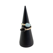 Load image into Gallery viewer, "Black cone-shaped jewelry stand with a Larimar &amp; Amber Sterling Silver ring on a white background," - Down to Earth.
