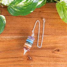 Load image into Gallery viewer, Layered 7 Charka Pendulum top down with plants on a style background - Down To Earth

