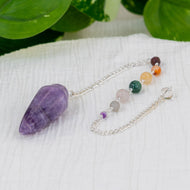 Amethyst Pendulum with Chakra stones on white cloth - Down to Earth 