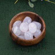 Pink Calcite in a wooden bowl on a green cloth - Down to Earth 
