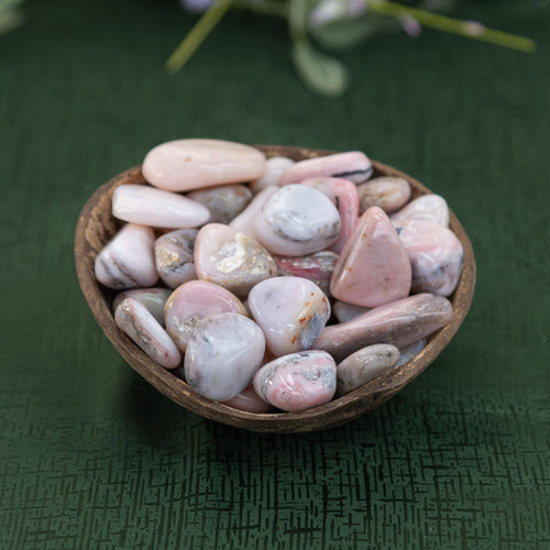 Pink Opal in a coconut shell on a green cloth - Down to Earth 