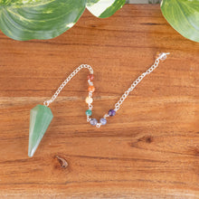 Load image into Gallery viewer, Premiere Green Aventurine Faceted Pendulum with 7 Chakra top down with plants on a style background - Down To Earth
