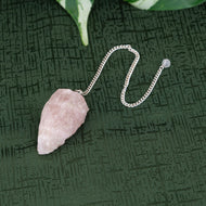 Raw Rose Quartz Pendulum on a green background - Down to Earth 