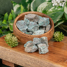 Load image into Gallery viewer, Turquoise Raw displayed on a colorful background in a wooden bowl side angle - Down to Earth
