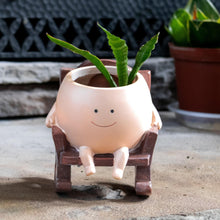 Load image into Gallery viewer, Rocking Chair Planter Pot front facing with a plant on a styled background - Down to Earth
