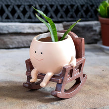 Load image into Gallery viewer, Rocking Chair Planter Pot angled with a plant displayed on a styled background - Down to Earth
