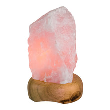 Load image into Gallery viewer, Rough Rose Quartz Lamp with the light on with a white background - Down To Earth
