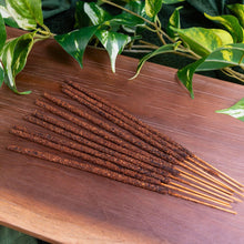 Load image into Gallery viewer, "10pk of Sacred Elements Incense Sticks on a wooden plank with green foliage in the background," - Down to Earth.
