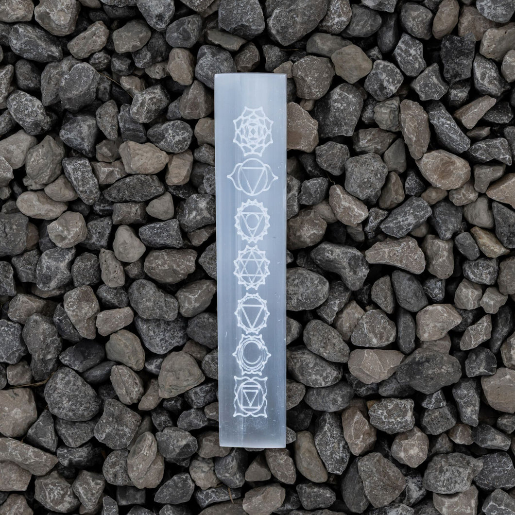 Selenite engraved Chakra Ruler on a rock background - Down to Earth 
