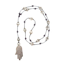Load image into Gallery viewer, "Necklace with Hamsa hand pendant and black cord on a white background," - Down to Earth.
