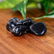 Snowflake Obsidian Tumbled on a wooden surface - Down to Earth