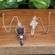 Spinning Merkaba Pendulum up close with plants displayed on a styled background - Down To Earth