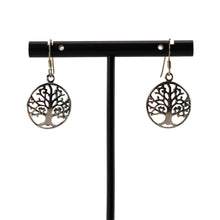 Load image into Gallery viewer, "Tree of life earrings on a black earring stand against a white background," - Down to Earth.
