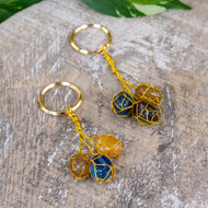 Triple Caged Gemstone Key Chain on a wooden surface - Down to Earth 