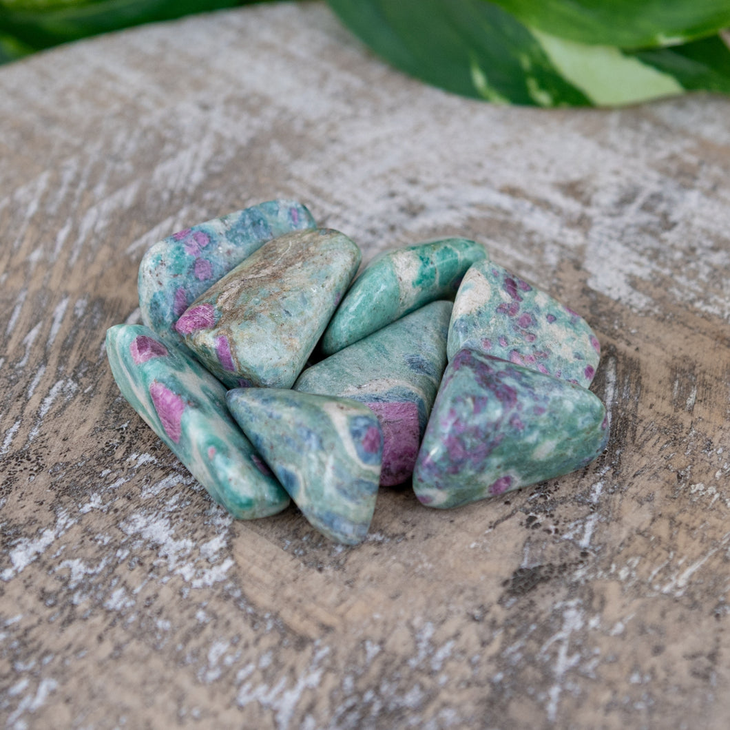 Tumbled Ruby Fuchsite on a wooden surface - Down to Earth 