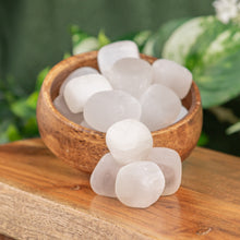 Load image into Gallery viewer, Tumbled Selenite displayed on a wooden surface in a bowl whilst over flowing second angle - Down to Earth
