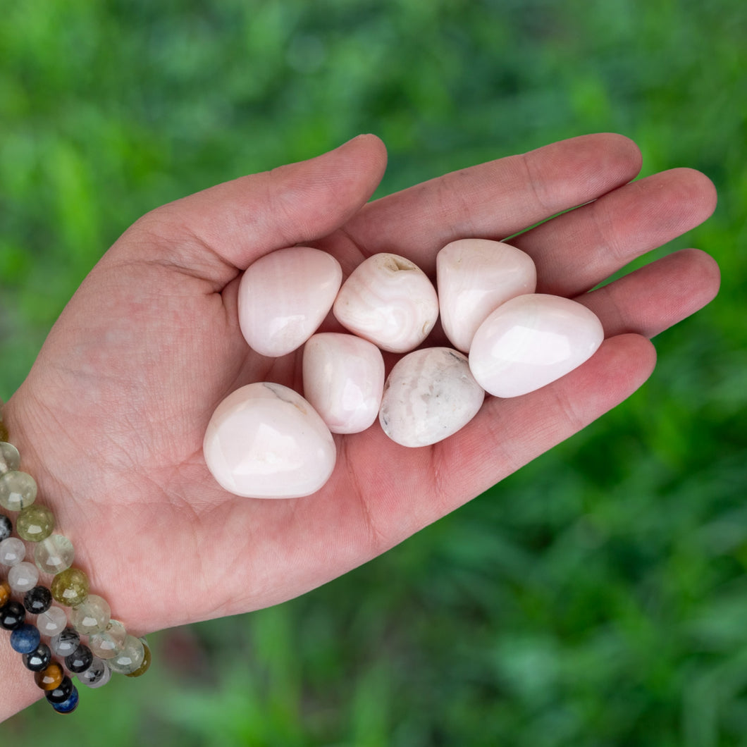 Tumbled Pink Calcite in the palm of a hand - Down To Earth