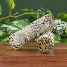 Load image into Gallery viewer, White Sage Smudge Stick 1x4 with plants displayed on a styled background - Down to Earth
