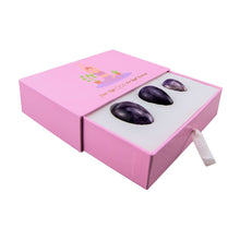 Load image into Gallery viewer, &quot;An open pink box with three amethyst yoni eggs within it,&quot; - Down to Earth.
