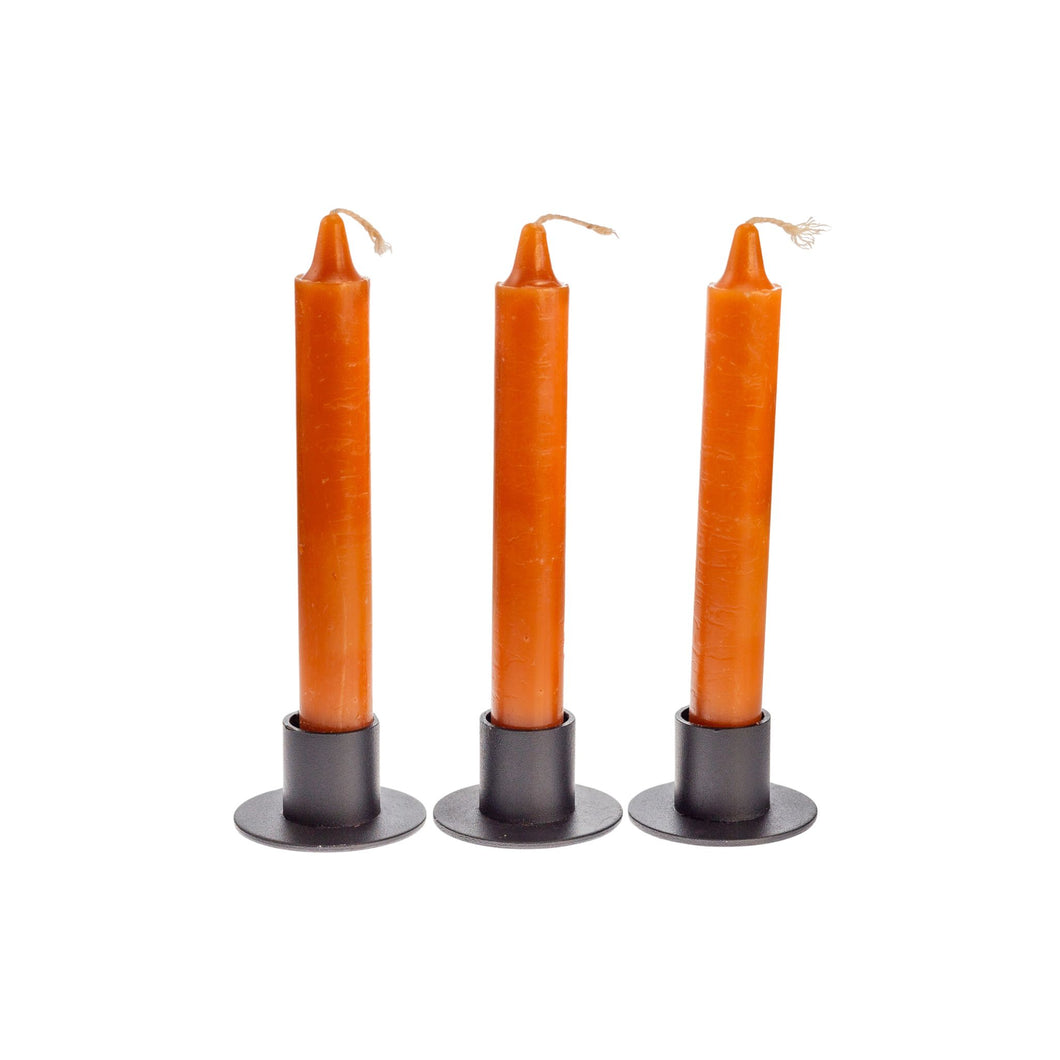 Photograph of three brown ritual candles standing upright side by side. - Down to Earth.