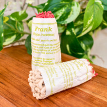 Load image into Gallery viewer, "Rope incense with packaging labeled 'Frank' on a wooden surface with green leaves in the background," - Down to Earth.
