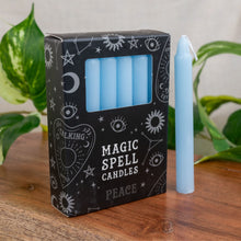 Load image into Gallery viewer, "Box of 'Magic Spell Candles' with a single candle on a wooden surface," - Down to Earth.
