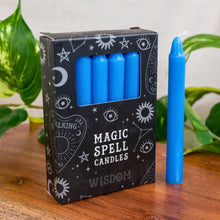 Load image into Gallery viewer, "Box of blue magic spell candles with a single candle on a wooden surface," - Down to Earth.
