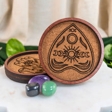 Load image into Gallery viewer, "Two wooden coasters with engraved designs on a marble surface with crystals," - Down to Earth.
