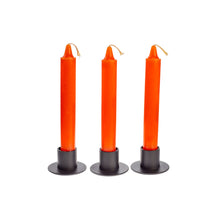 Load image into Gallery viewer, Front view of three orange ritual candles standing upright side by side. They are in black metal candle holders. - Down to Earth.
