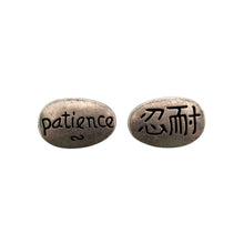 Load image into Gallery viewer, "Two metallic oval stones with engraved text on a white background," - Down to Earth.
