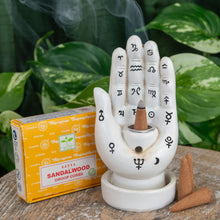 Load image into Gallery viewer, &quot;Satya Sandalwood Dhoop Cones next to a Palmistry Incense Burner on a wooden plank with green foliage in the background,&quot; - Down to Earth.
