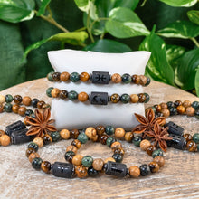 Load image into Gallery viewer, "Pisces Zodiac Bracelet on a white pillow surrounded by assorted Zodiac Bracelets with green foliage in the background," - Down to Earth.
