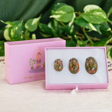 Load image into Gallery viewer, &quot;A three-piece unakite yoni egg set propped up against its lid with plants in the background,&quot; - Down to Earth.
